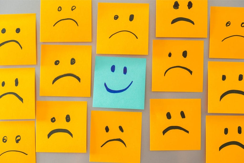 A group of yellow sticky notes with smiley faces on them.